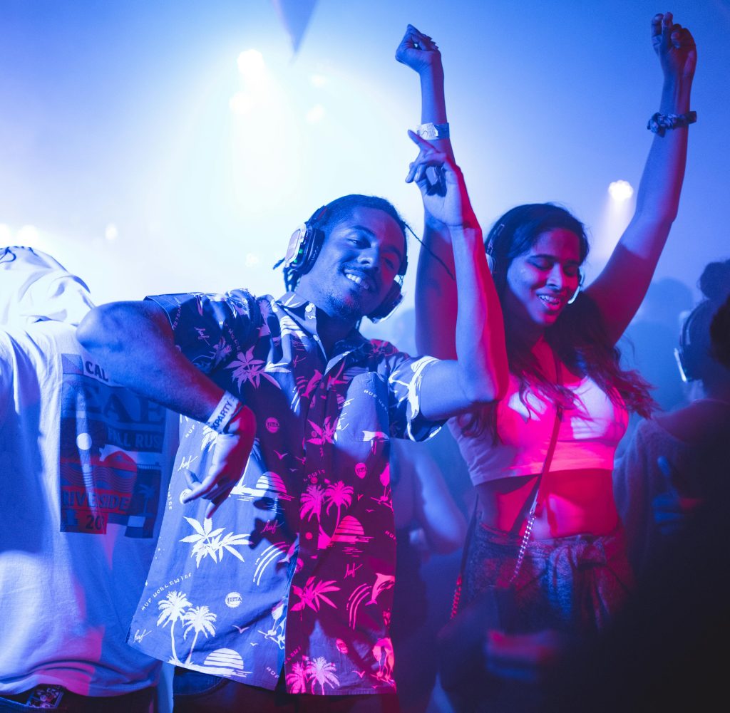 Vibrant nightclub scene with people dancing energetically to music.